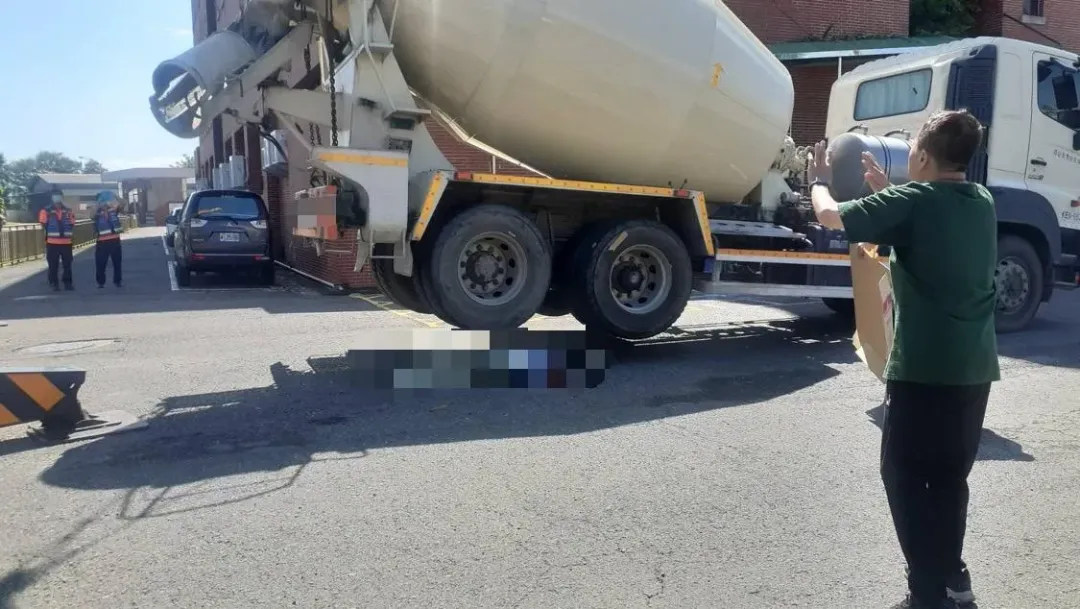 郭女在車頭前拆預拌混凝車車牌時,預拌混泥車李姓駕駛疑未注意,竟開車直接輾過郭女。(圖/翻攝畫面)