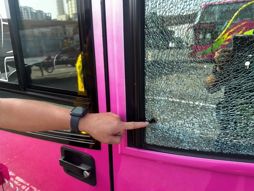 遊覽車車窗遭人擊破,玻璃碎成蜘蛛網狀,警方調閱監視器逮獲黃嫌。(圖/中天新聞)