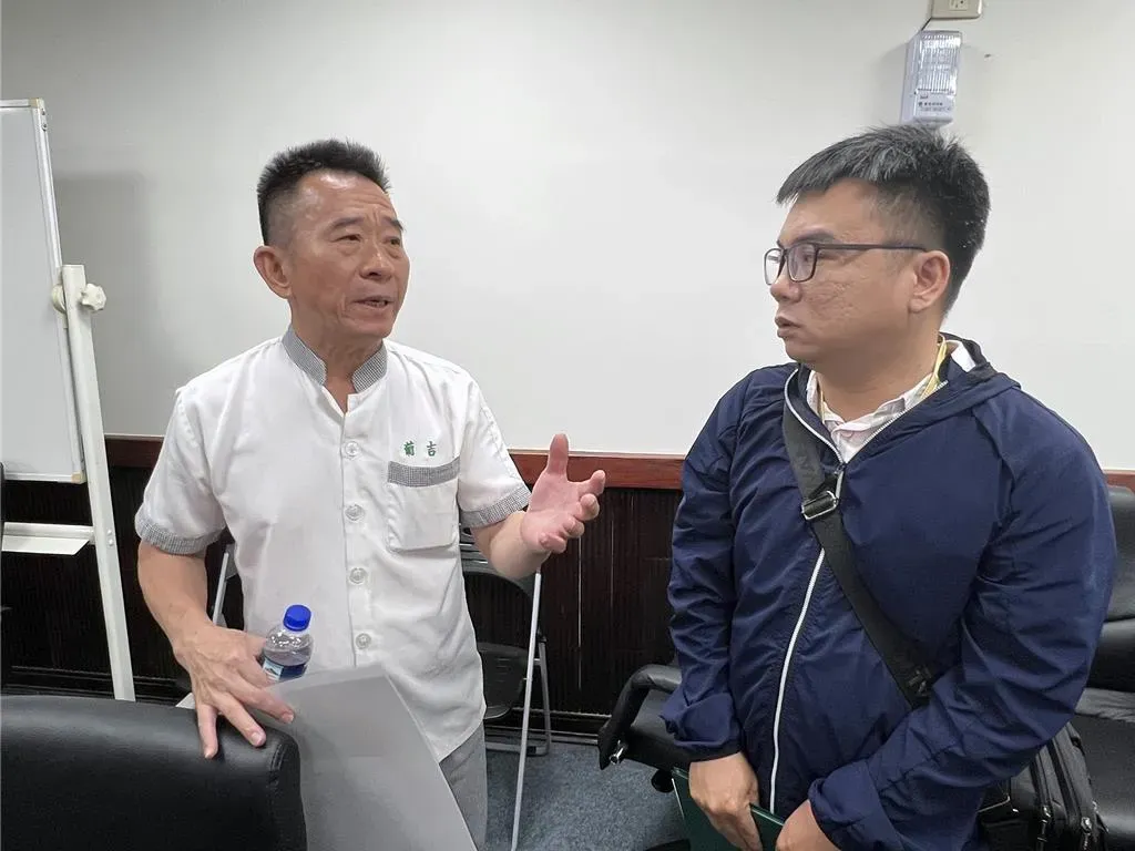 葡吉食品老闆張正宏(左)向台南市衛生局人員朱俊穎溝通逾期原料問題。(圖/中時新聞網)