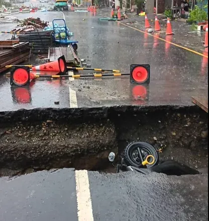 鳳山區新富路正在進行的地下連通管工程留下巨大坑洞,但風雨一來,防護警戒設施全吹走。(圖/翻攝自李雅靜臉書)