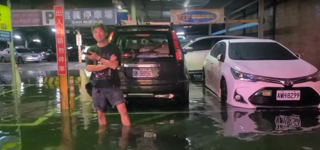 有車主站在愛車前方,其水勢淹到他小腿肚高度。(圖/中天新聞)