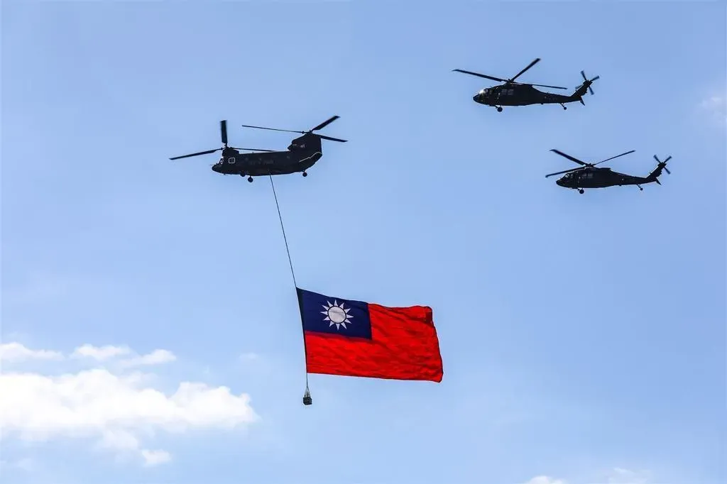 CH-47SD運輸直升機在國歌領唱階段吊掛國旗進場，吸引不少民眾拿起手機拍攝。 （記者劉程鈞攝）