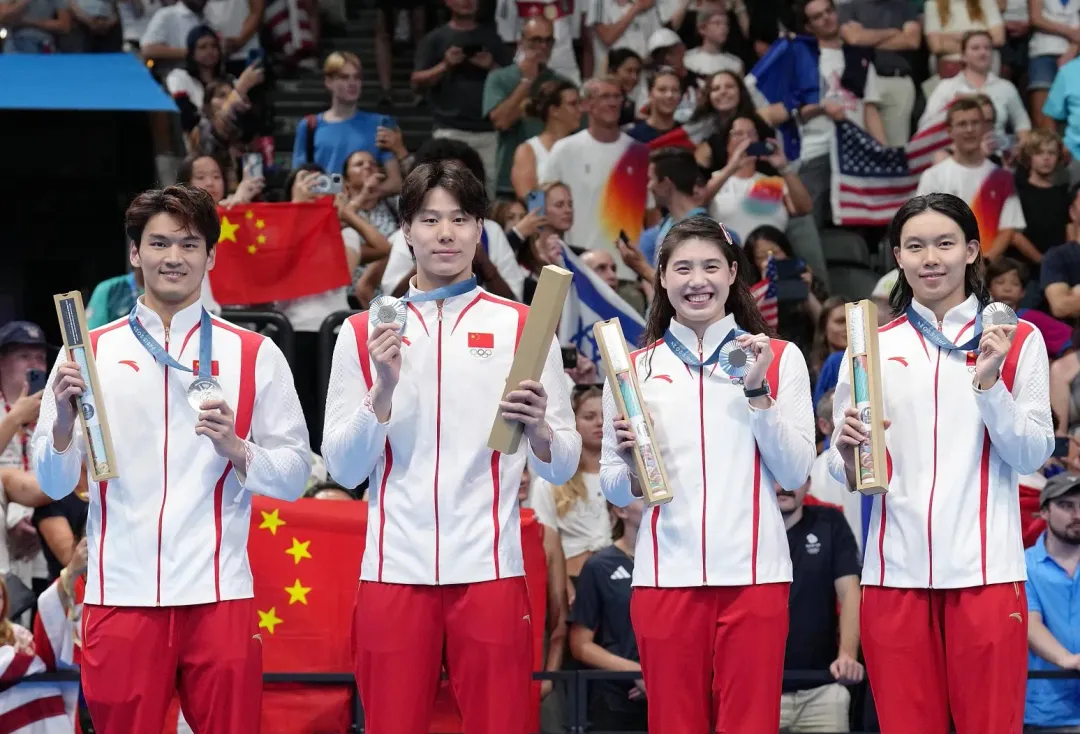 覃海洋(左二)參加今年巴黎奧運，與隊友們在男女4X100米混合泳接力項目中奪得銀牌。（圖／新華社）