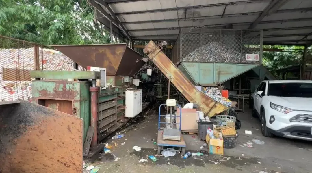 女工人發現機器卡住上前查看後拿鐵棒上去要敲擊或打通回收物，途中不慎掉落機器內。（圖／翻攝畫面）