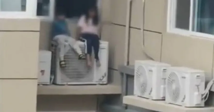 河南一對夫妻吵架,妻子竟把孩子放在23樓外的冷氣機上。(圖/翻攝自微博)