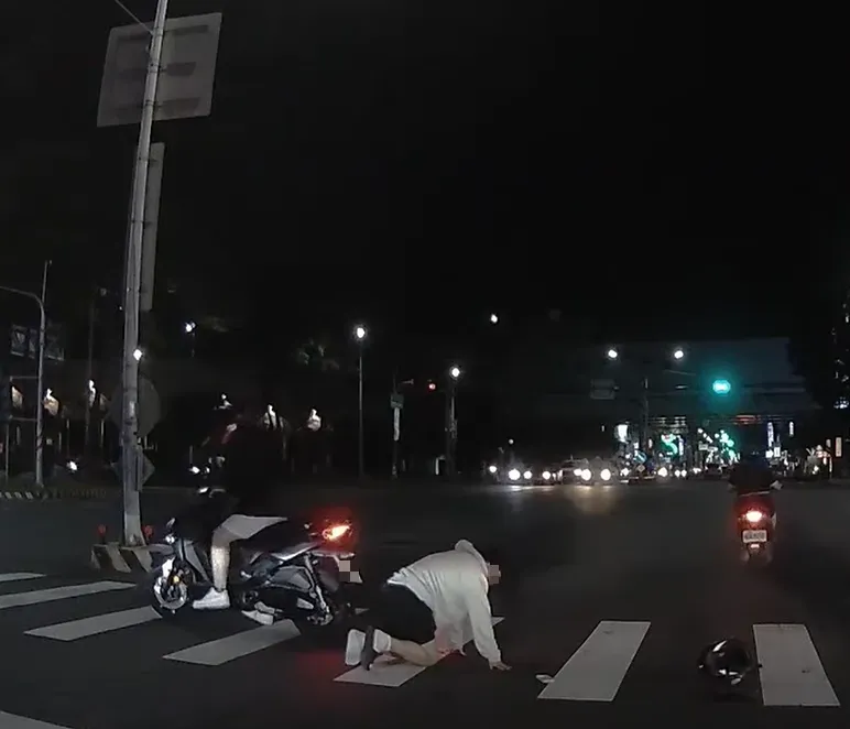 白衣男生從後座摔下時,似乎并沒有扣緊安全帽,所以安全帽也在承受了突如其來的撞擊後與頭部「分離」。(圖/翻攝自臉書社團《爆廢公社二館》)