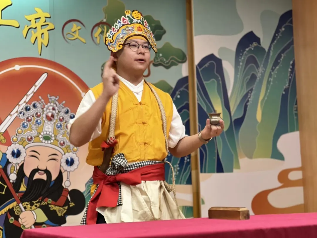 林承勳雙手擺著特定指法、打著赤腳,演示了一段這個來自澎湖的無形文化資產。(圖/新北市民政局提供)