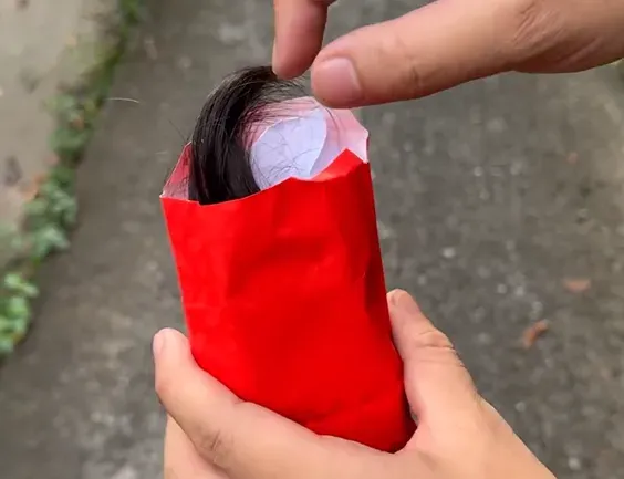 紅包袋裡的頭髮和紙條顯示這個紅包大有問題。（圖／網友ichiro_ghostskintattoo授權提供）