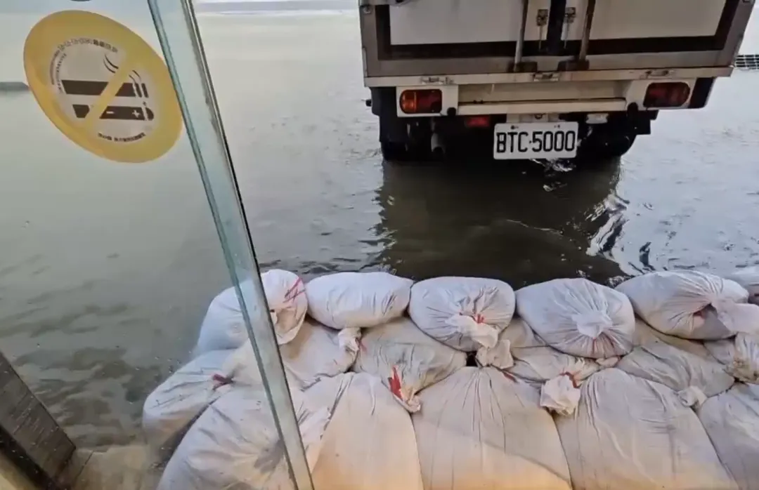 冬山鄉1處麵包店業者在店外堆起沙包，但積水已經快要淹過沙包高度了。（圖／中天新聞）