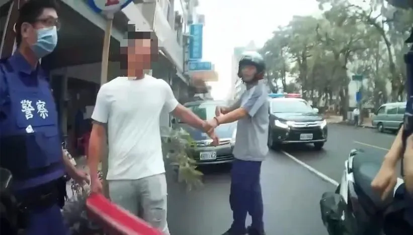 胡姓男子（白衣者）被警方帶回。（圖／翻攝畫面）