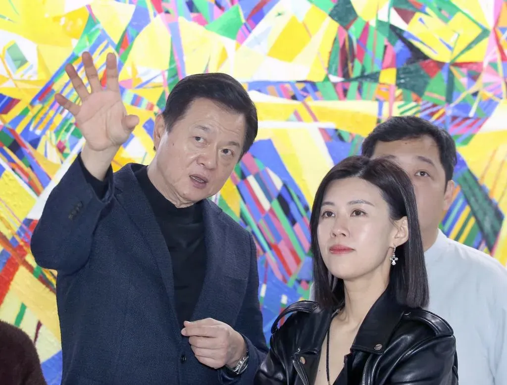 旺旺集團副董事長周錫瑋（左）的「一合相」畫展27日在松山文創園區一號倉庫盛大開幕，並親自為參觀民眾講解畫作。（圖/中國時報/范揚光攝）
