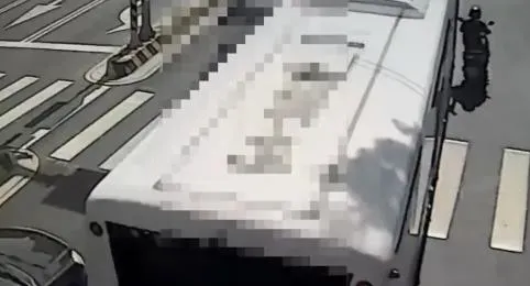 楊女倒地後，機車車尾卡進公車右後輪，好在楊女未被捲入車底。（圖／翻攝畫面）