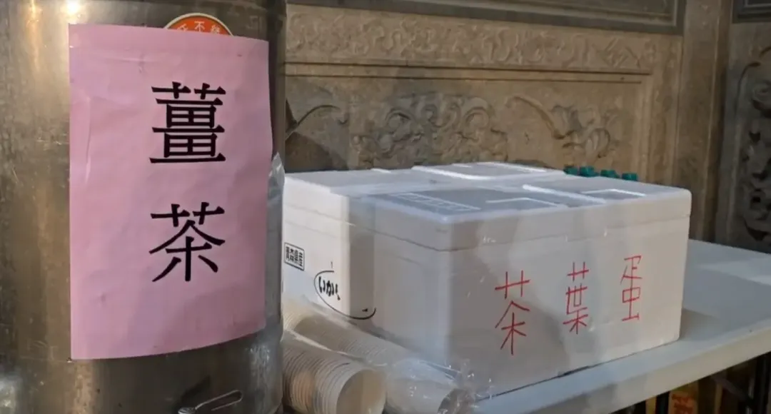 廟方為排隊民眾貼心準備熱薑茶、茶葉蛋，還有八寶粥跟黑糖餅乾給民眾補補體力、暖暖身子。（圖/中天新聞）