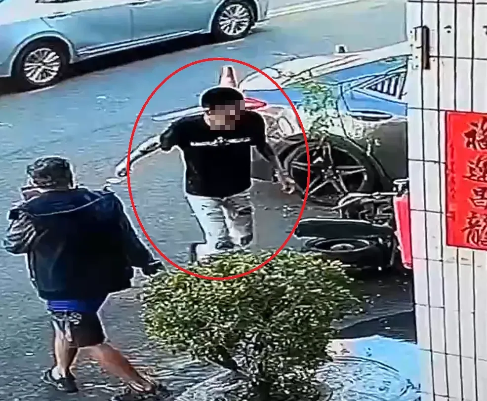 監視器拍到林男(紅圈處)撞車後一瘸一拐地下車,走到路邊坐著打盹。(圖/中天新聞)