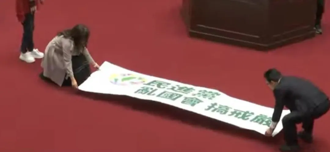 抗議布條由白委林國成、麥玉珍鋪在議場中央。（圖/中天新聞）