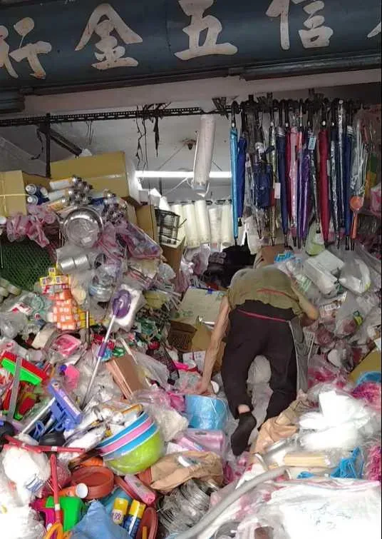 老闆一邊踩著商品一邊到處尋找客人要的東西。(圖/翻攝自臉書/路上觀察學院)