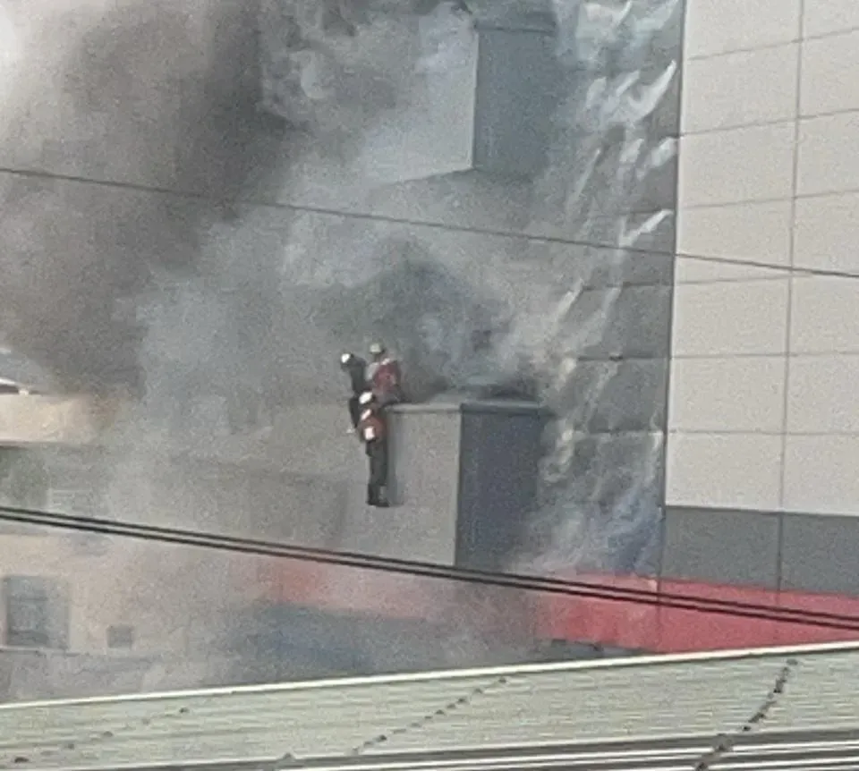 19日下午1時42分許，廠區附近有民眾目擊有人正要跳樓逃生，被消防員救上來。（圖／民眾提供）