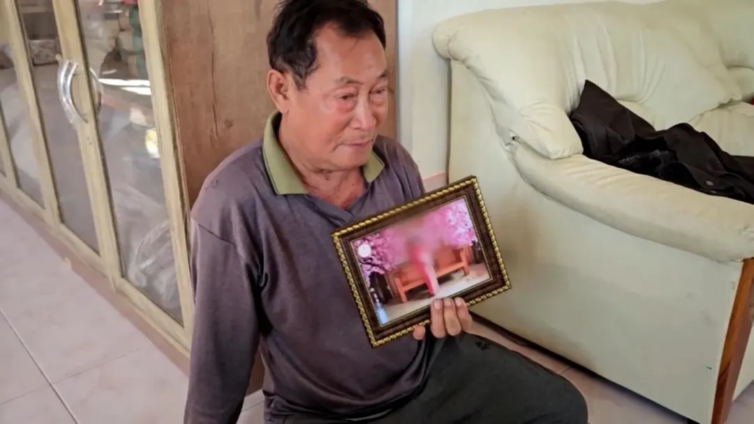 父親悲傷拿著死者瓊拉（Jonglak Duangmanee）的照片。（圖／路透社）
