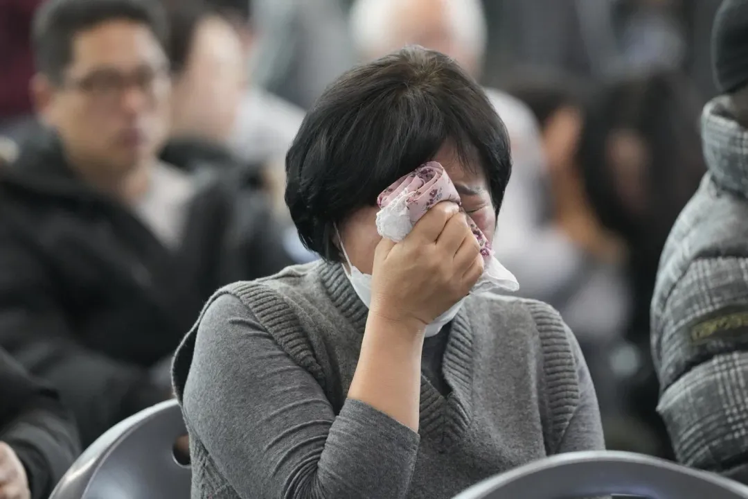 一名家屬在空難後悲傷掩面哭泣。(圖/美聯社)