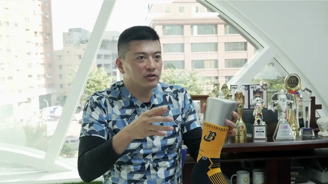 創辦人鐘志誠講述sNug機能襪繁複工法，後方滿是國內外設計大賞獎盃，用心研發成果看得見。(圖/中天新聞攝)