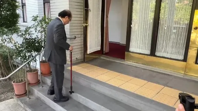 柯建銘受訪完畢後拄著拐杖進入議場。（圖／中天新聞）