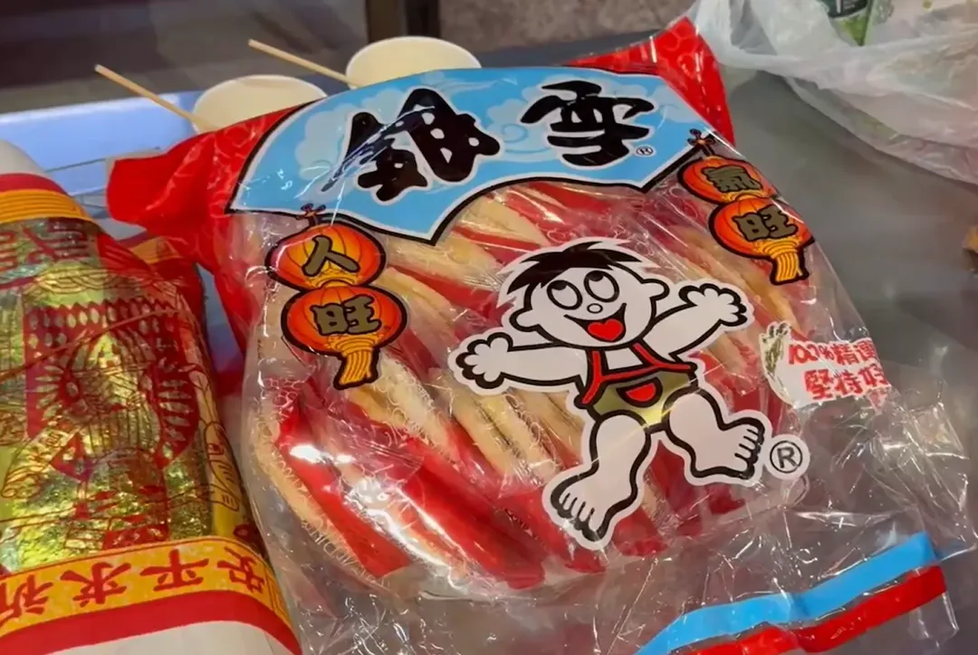 信徒準備旺旺仙貝等零食和仙草蜜，希望土地公多多庇佑、事業旺旺。（圖／翻攝畫面）