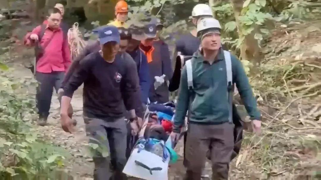 救護人員協助傷者脫困合力搬運下山送醫治療。（圖／翻攝畫面）