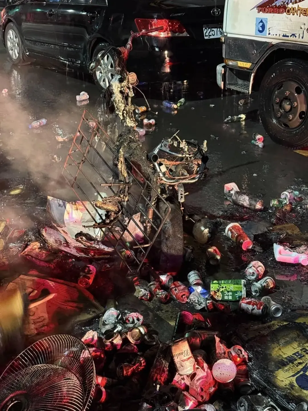 消防人員將火勢撲滅後，燒焦的機車和回收物散落滿地，現場一片狼藉。（圖/中天新聞）