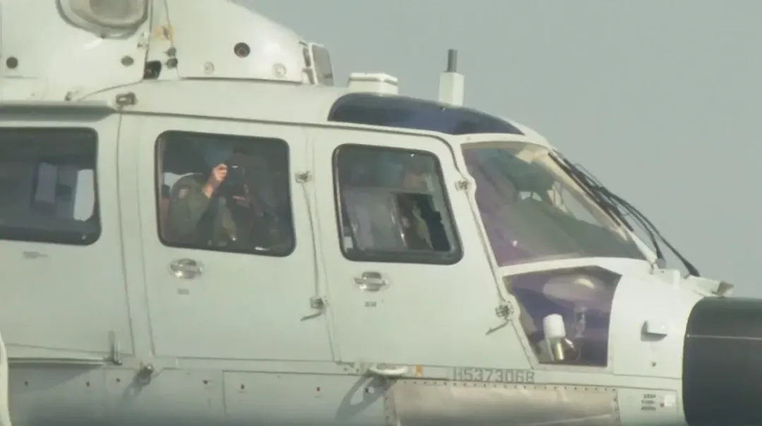 18日，一架解放軍海軍直升機逼近菲國公務機，機上可見中方人員正在拍攝。（圖／美聯社）