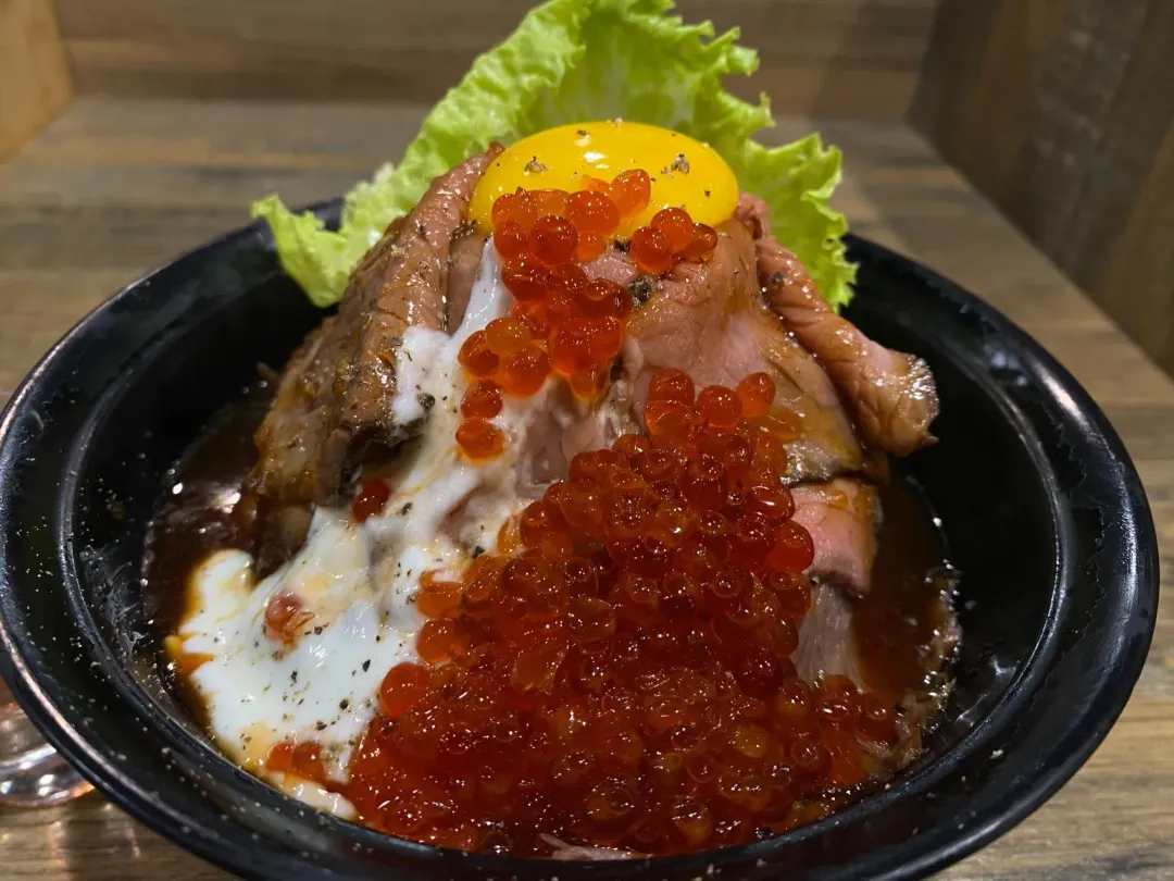 火山月見聖母丼鋪滿翼板肉、白色松露酸奶醬，「頂峰」處以生蛋黃點綴成滿月造型。（圖／黃宏輝提供）