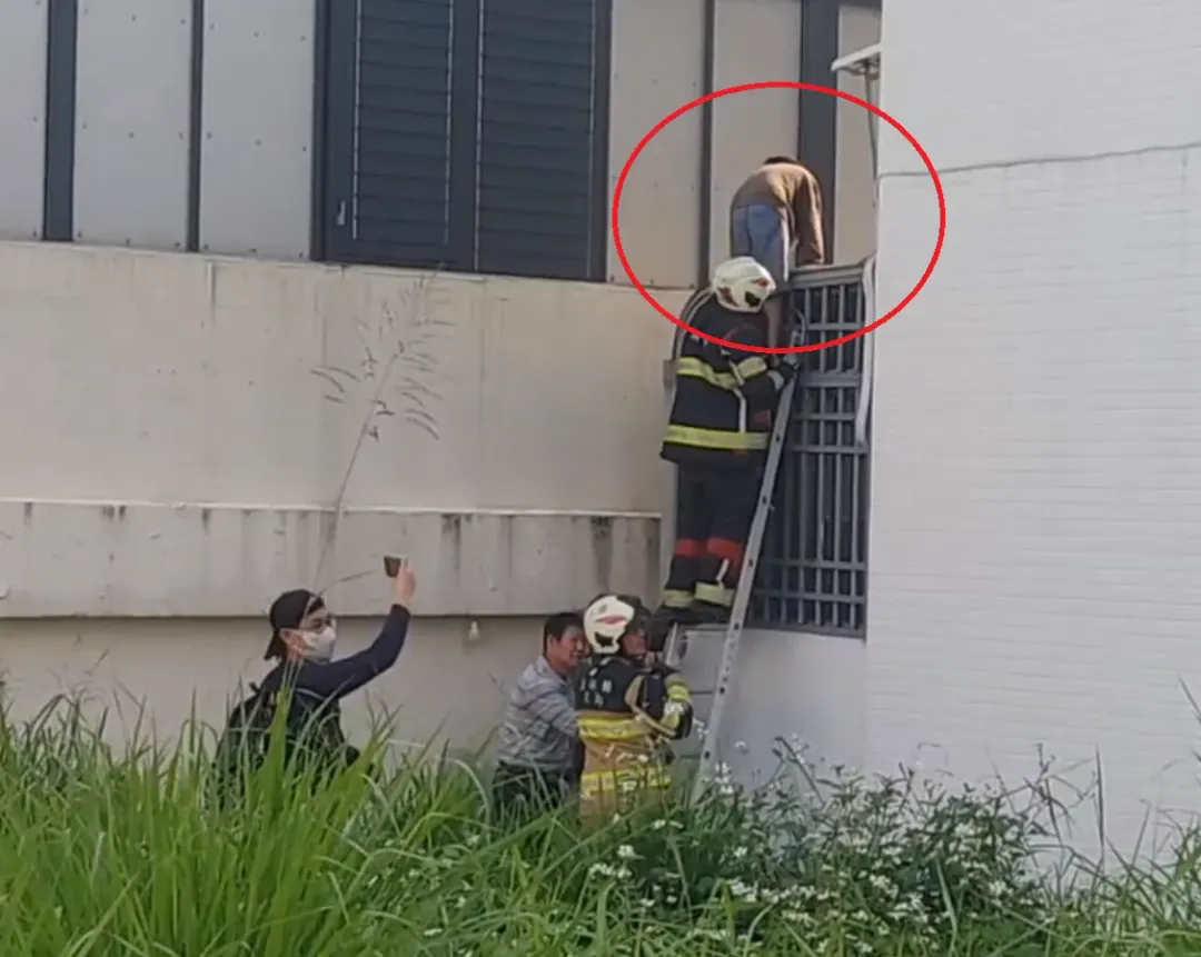救難人員協助防火巷的男屋主和小孩爬梯脫困。(圖/中天新聞)