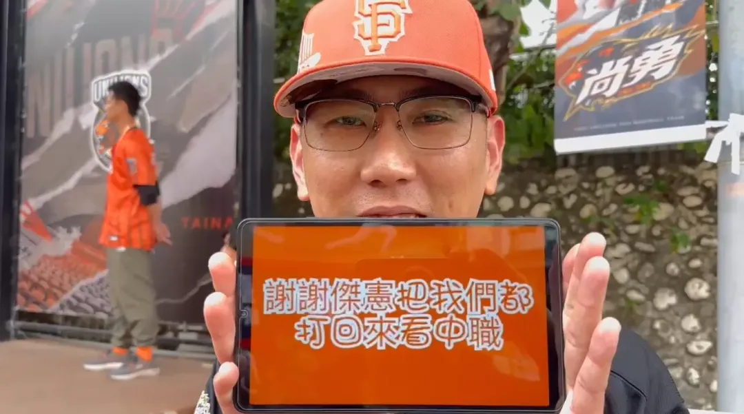 一位球迷拿著手機顯示「謝謝傑憲把我們都打回來看中職」。（圖／中天新聞）