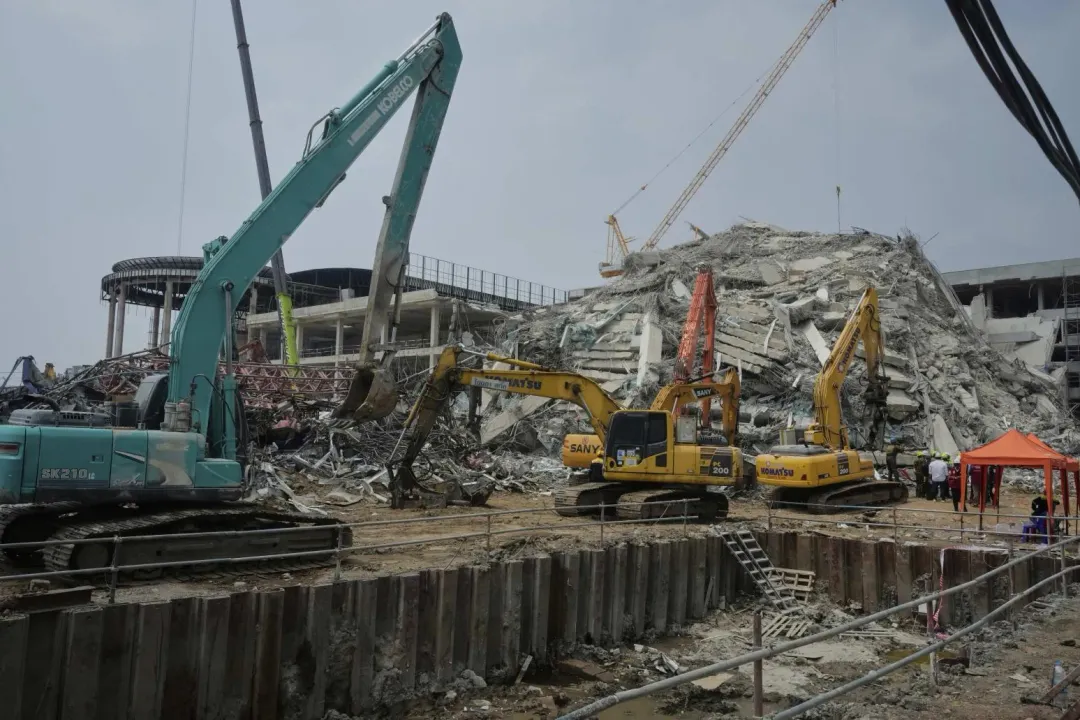 緬甸強震造成曼谷一棟興建中的審計大樓倒塌。圖為救援人員在現場清理廢墟進行搜救作業。(圖/美聯社)