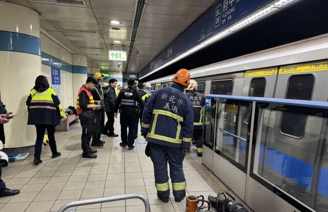 消防救護人員趕抵月台救出受困車底女子。（圖／翻攝畫面）