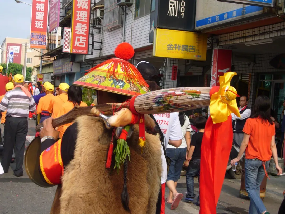報馬仔扛著長紙傘、豬腳、韭菜等物品，一路傳遞媽祖勸世向善的文化精神。（圖／楊登嵙提供）