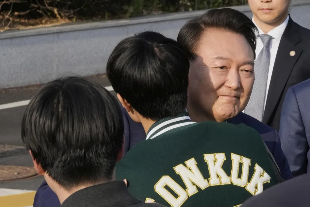 尹錫悅與一名在官邸外的支持者擁抱。(圖/美聯社)