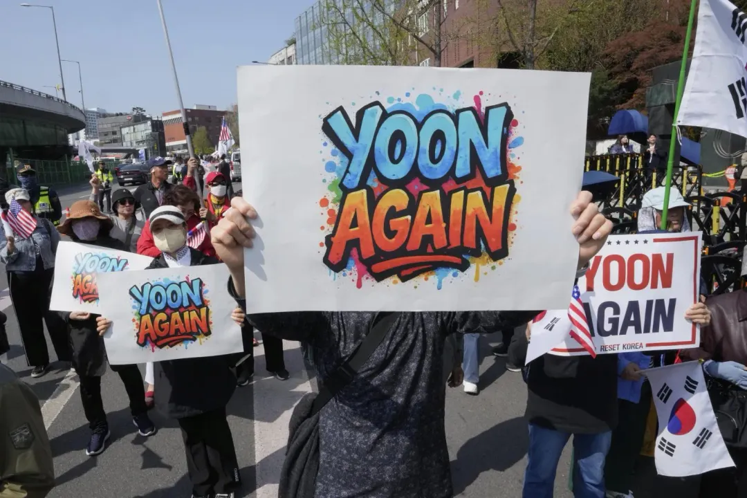 尹錫悅支持者聚集在官邸附近,高舉「YOON AGAIN」標語。(圖/美聯社)