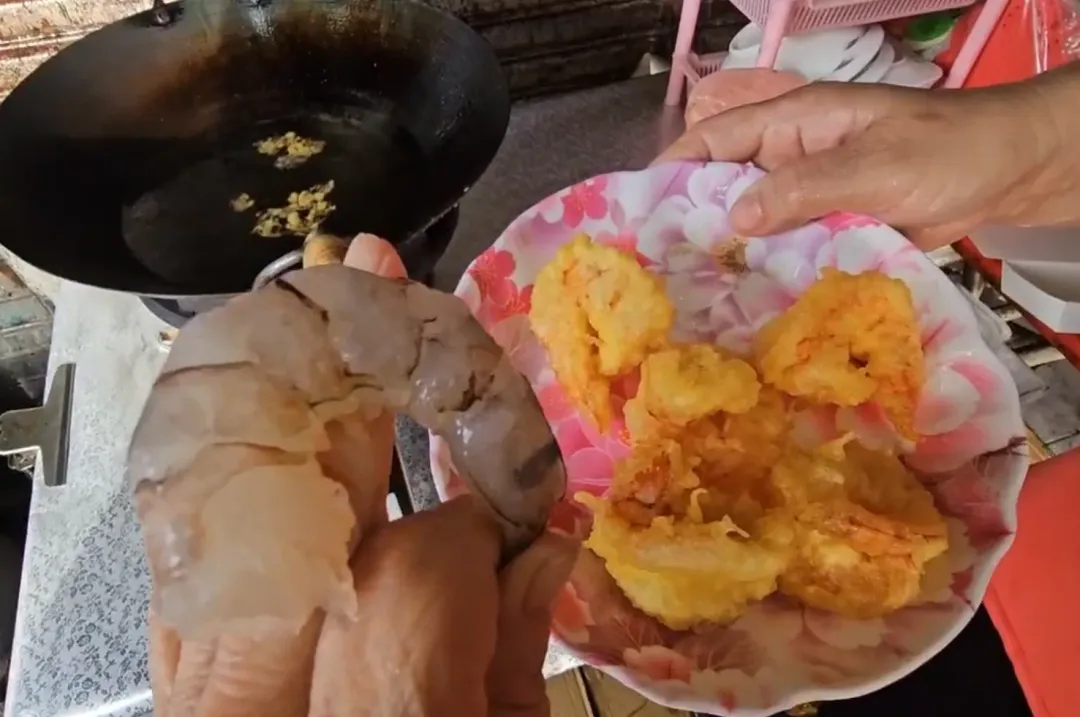當事業者拿出自家餐廳使用的草蝦和炸好的蝦球比對大小。（圖／中天新聞）