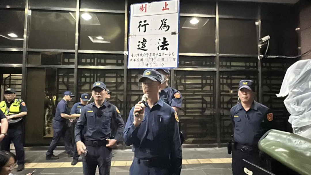 中正一分局分局長第二次舉牌「制止」。(圖/塗豐駿攝)