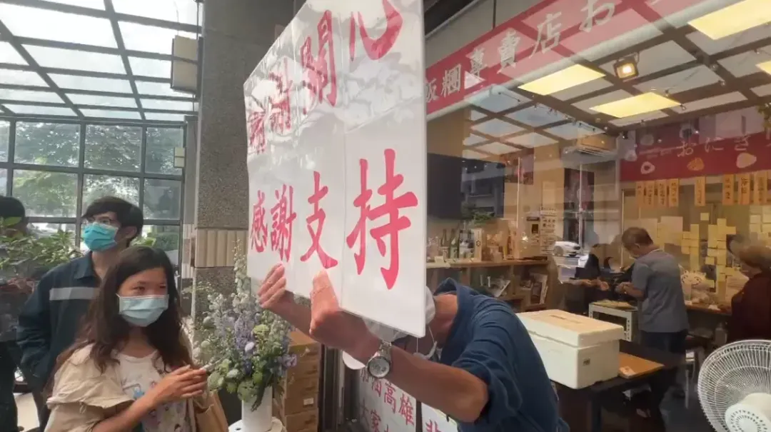 老闆拿板子鞠躬感謝支持。（圖／中天新聞）