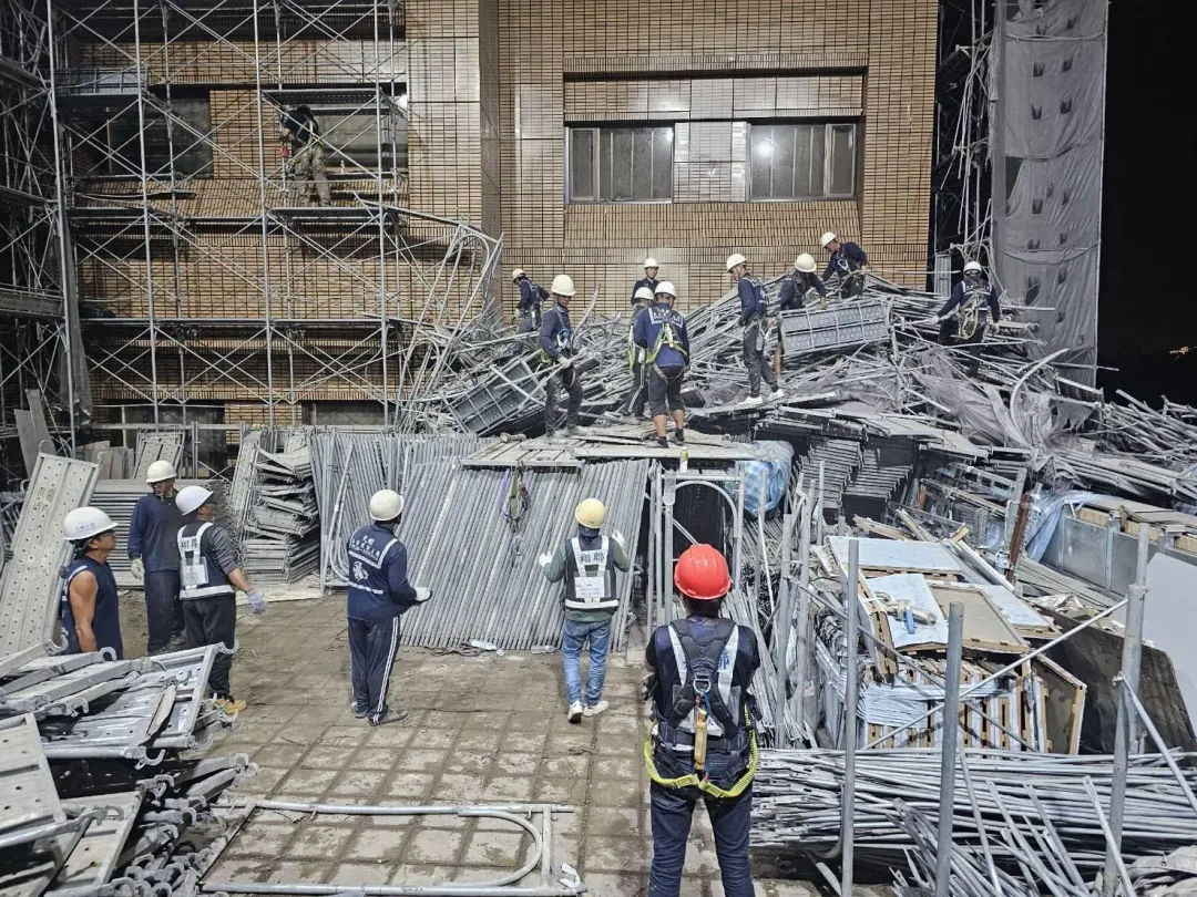 承商採人工方式搬移層層卡住的施工架，連夜進行移除作業。（圖／北市府提供）