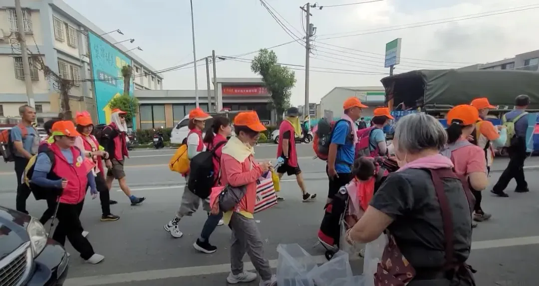 年約70歲的老婦人默默地拿著垃圾袋，主動幫忙替香燈腳們回收沿途的垃圾。（圖／翻攝自白沙屯媽祖網路電視台）