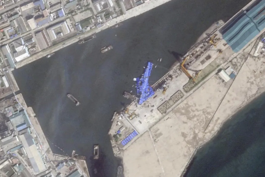 北韓軍艦下水過程中翻覆受損，以藍色帆布遮蓋。（圖／美聯社）
