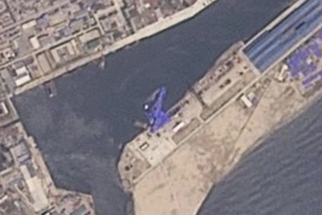 衛星影像顯示下水時發生事故的驅逐艦被以藍色防水布覆蓋著。(圖/美聯社)