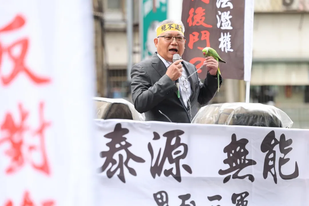 捍衛用藥安全藥師公會五度抗爭,藥師公會全聯會理事長黃金舜帶著鸚鵡,諷諭衛福部部長邱泰源只會「鸚鵡學舌」地重複空洞官話。(圖/藥師公會全聯會提供)