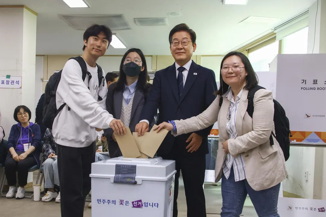 選情一路看好的南韓共同民主黨候選人李在明（右二），29日與年輕民眾在首爾一個投票站提前投票。（圖/美聯社）