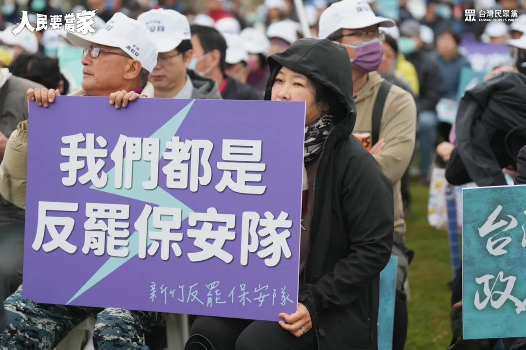 民眾黨成立「保安隊」反罷免,引來綠營質疑。圖為民眾在民眾黨宣講活動中,手持「反罷保安隊」標語。(圖/翻攝民眾黨臉書)