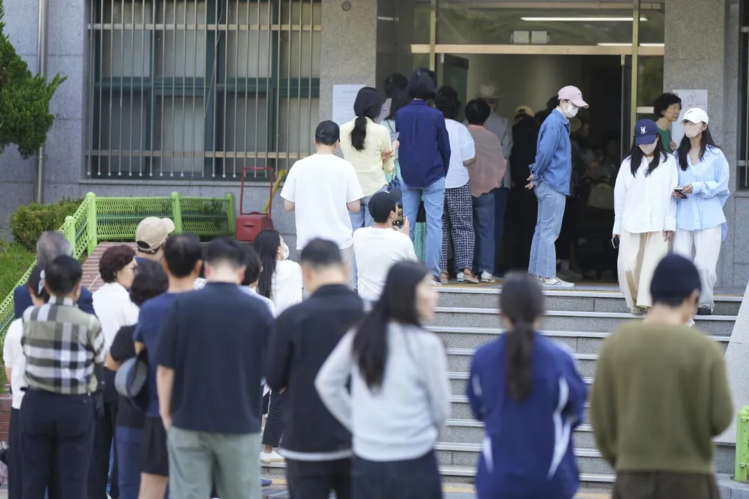 南韓各地的投票站一早便有大批民眾排隊。(圖/美聯社)