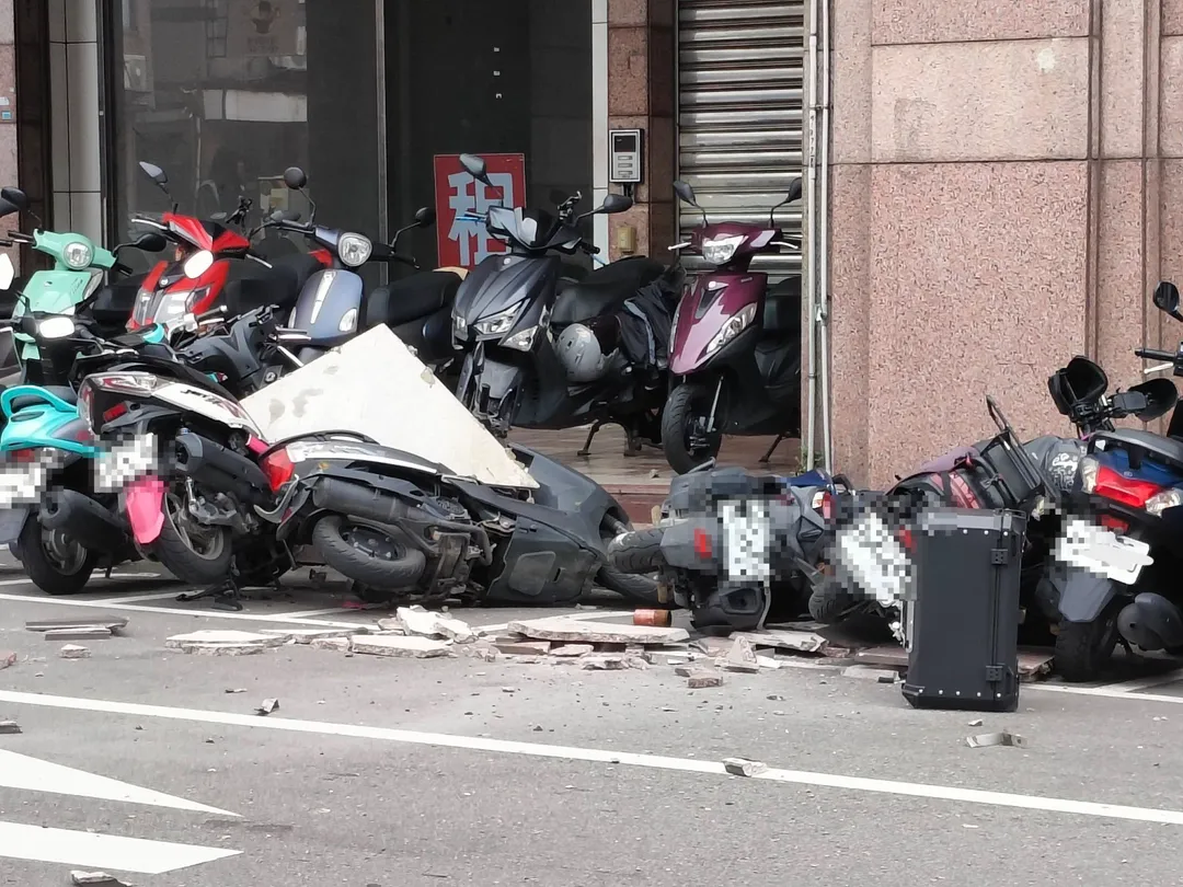苗栗市中山路與至公路口一棟大樓今（6）日發生外牆磁磚掉落事件，路邊停放的6輛機車遭到波及。（圖/翻攝自臉書社團「苗栗大小事」）