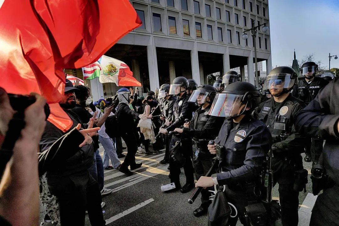 身著防暴裝備的洛杉磯警察組成防線，將抗議者推離洛杉磯市中心的聯邦大樓，沿街驅散。（圖／美聯社）